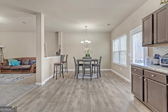 dining space featuring light hardwood / wood-style floors and a notable chandelier