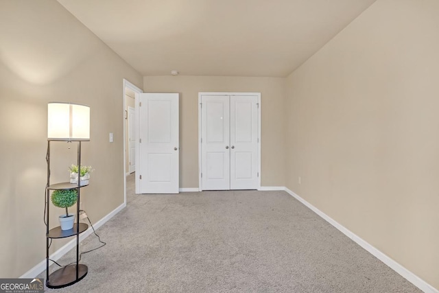 unfurnished bedroom featuring light colored carpet and a closet