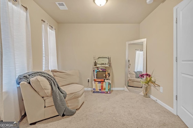 living area featuring light carpet