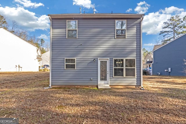 back of house with a lawn