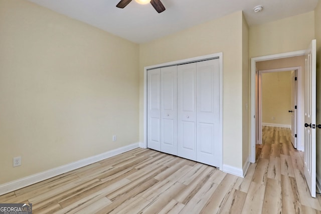 unfurnished bedroom with ceiling fan, a closet, and light hardwood / wood-style flooring