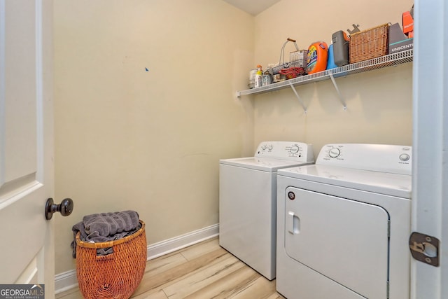 laundry area featuring washing machine and dryer and light wood-type flooring