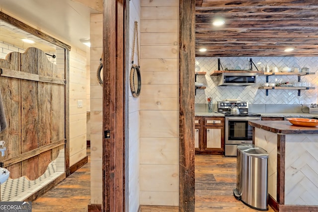 kitchen featuring tasteful backsplash, wooden walls, dark hardwood / wood-style flooring, and appliances with stainless steel finishes