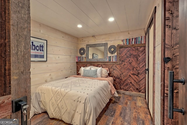 bedroom featuring wooden walls and dark wood-type flooring