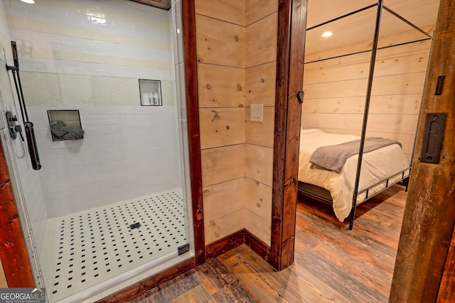 bathroom featuring walk in shower, wooden walls, and hardwood / wood-style flooring