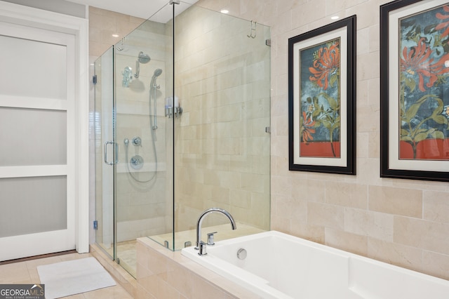 bathroom featuring tile patterned flooring, separate shower and tub, and tile walls