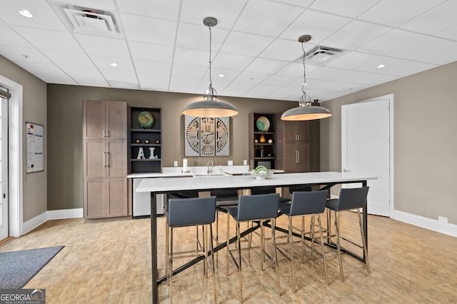 kitchen with a kitchen breakfast bar, a spacious island, hanging light fixtures, and built in shelves