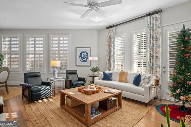 living room featuring ceiling fan, light hardwood / wood-style floors, and a wealth of natural light