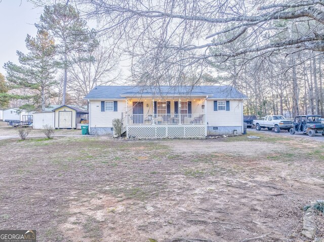 ranch-style home with covered porch and a storage unit