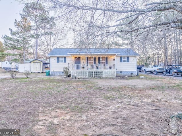 view of front facade with a storage shed, a porch, crawl space, and an outbuilding