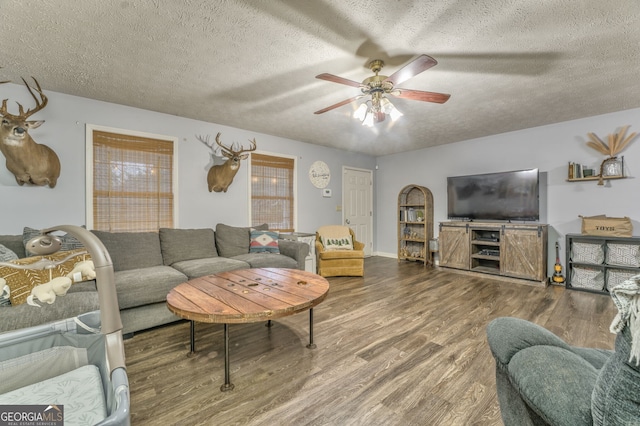 living room with a textured ceiling, ceiling fan, and wood finished floors