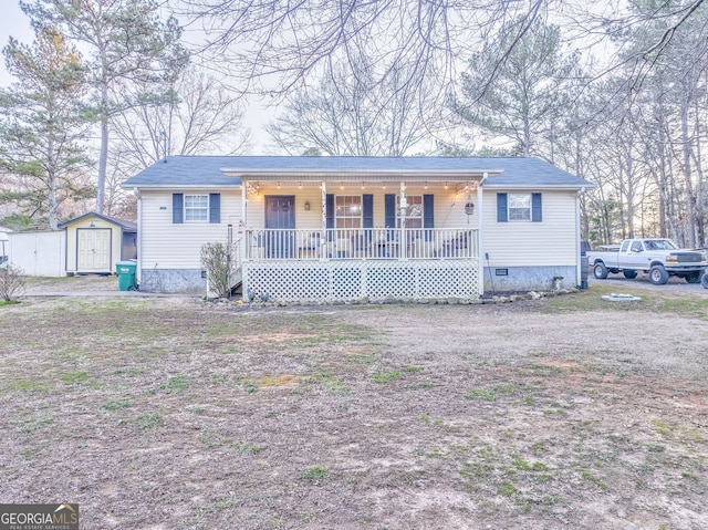 view of front of house with an outbuilding, crawl space, covered porch, and a storage unit