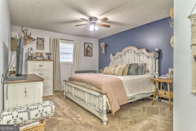 bedroom featuring a textured ceiling, ceiling fan, and light colored carpet