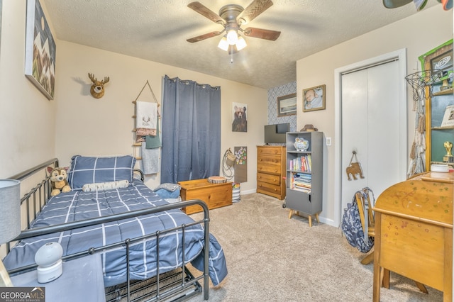 bedroom with baseboards, a ceiling fan, a textured ceiling, and light colored carpet