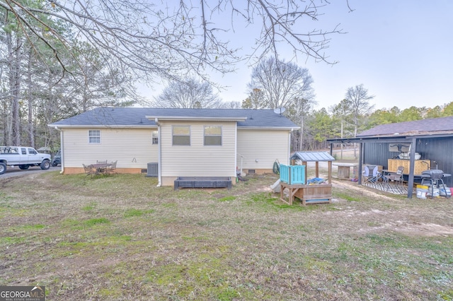 back of property with a yard, crawl space, and central air condition unit