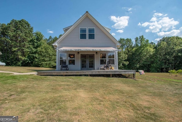 back of property with a lawn and french doors