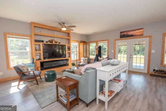 living room with plenty of natural light, ceiling fan, light wood-type flooring, and french doors