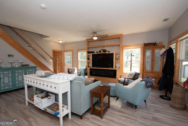 living room with ceiling fan, hardwood / wood-style floors, and a healthy amount of sunlight