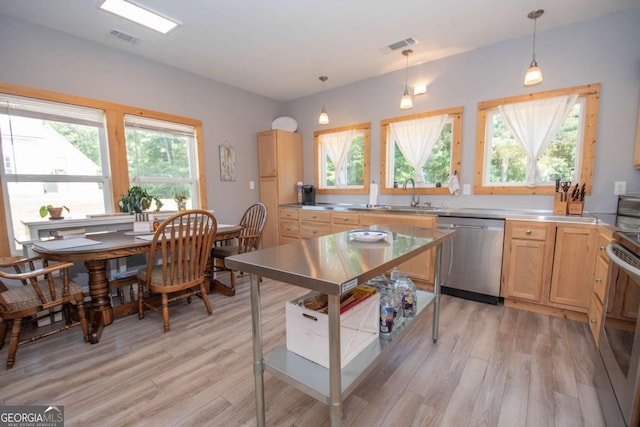 kitchen with light hardwood / wood-style floors, light brown cabinetry, hanging light fixtures, and appliances with stainless steel finishes