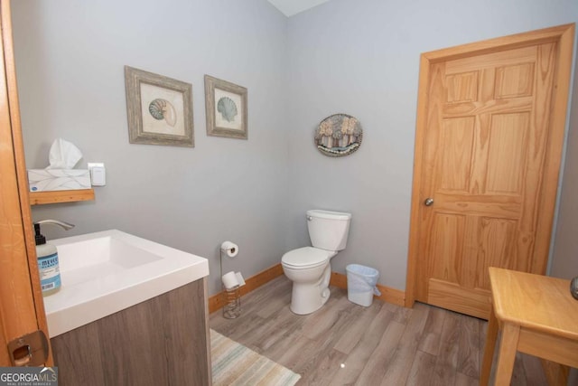 bathroom featuring wood-type flooring, vanity, and toilet