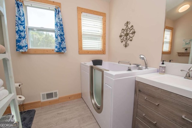 clothes washing area featuring light wood-type flooring and sink