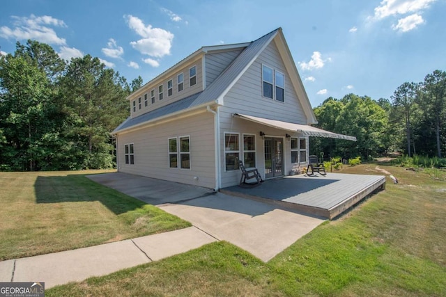 back of house featuring a lawn and a deck