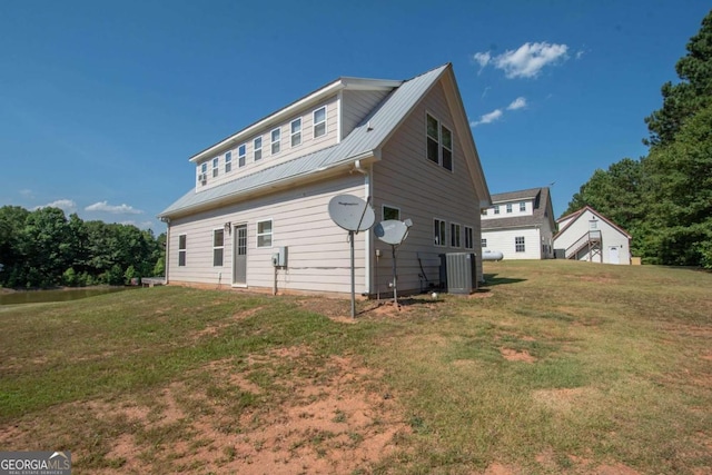 view of side of home with a yard and central AC unit