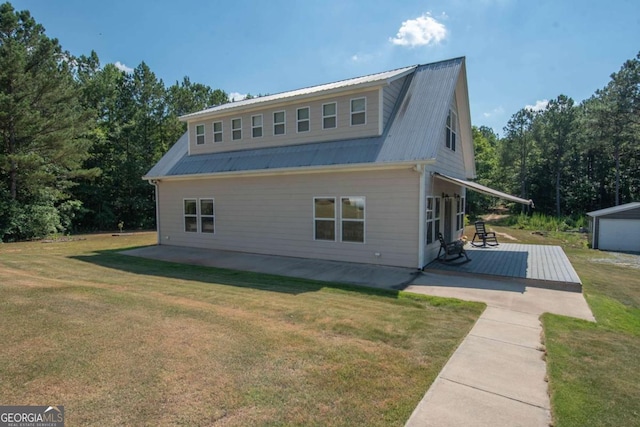 rear view of house featuring a yard, a patio, and a wooden deck