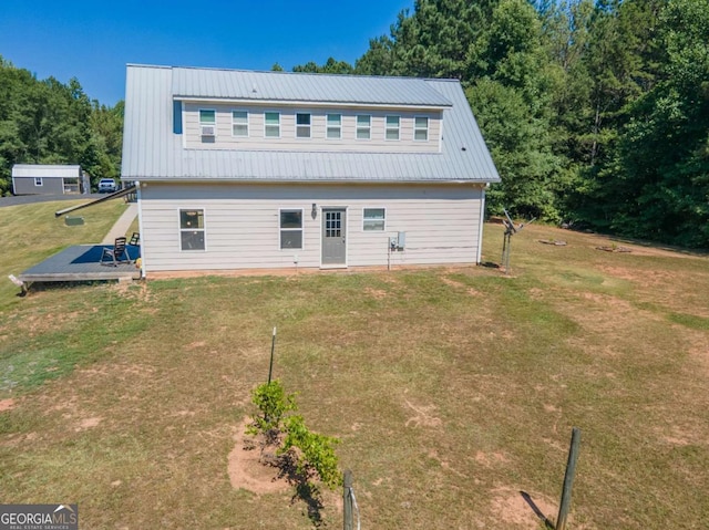 rear view of property with a yard and a wooden deck