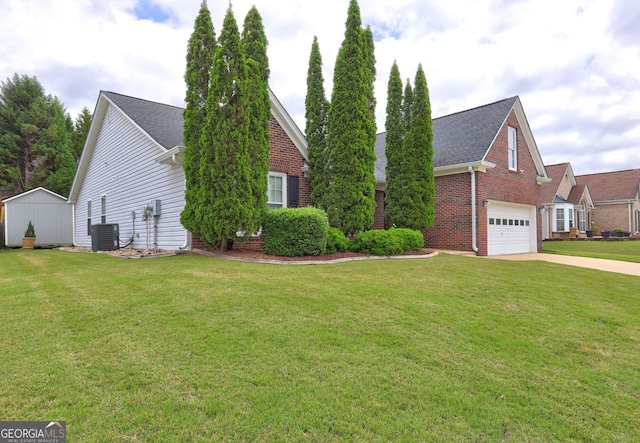 view of front of home featuring central air condition unit, a front lawn, and a garage