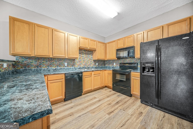 kitchen with light wood-type flooring, tasteful backsplash, a textured ceiling, sink, and black appliances