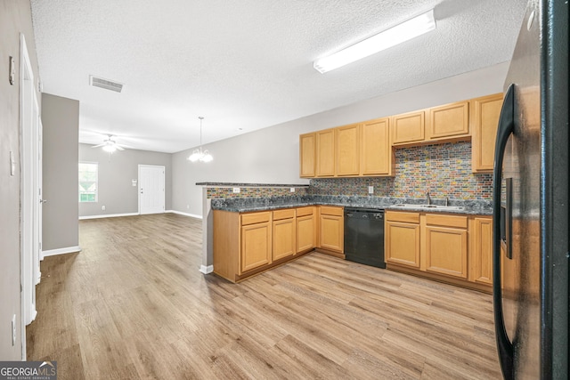 kitchen with kitchen peninsula, pendant lighting, light hardwood / wood-style floors, black appliances, and ceiling fan with notable chandelier