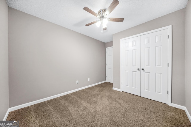 unfurnished bedroom featuring ceiling fan, a closet, carpet floors, and a textured ceiling