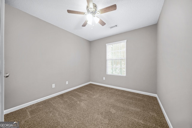 spare room with ceiling fan, carpet, and a textured ceiling