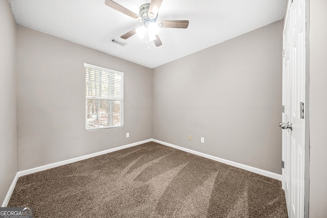 carpeted empty room featuring ceiling fan and a textured ceiling