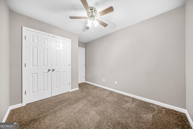 unfurnished bedroom featuring carpet, a textured ceiling, a closet, and ceiling fan