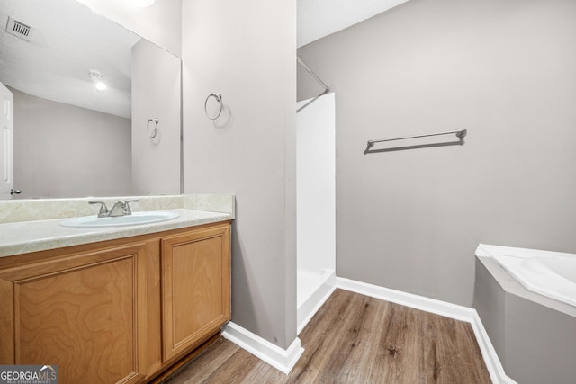 bathroom with hardwood / wood-style floors, vanity, and walk in shower