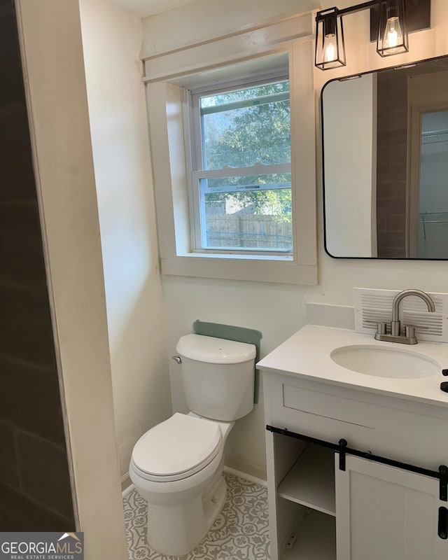 bathroom featuring vanity, tile patterned floors, and toilet