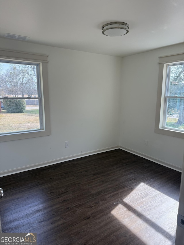 spare room featuring dark wood-type flooring