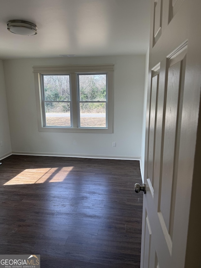 empty room with dark wood-type flooring