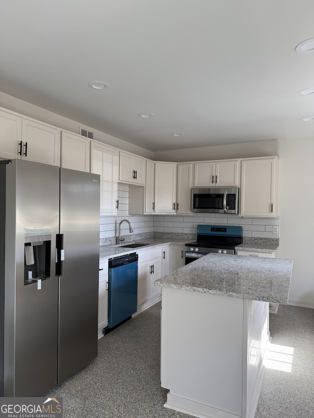 kitchen featuring white cabinetry, tasteful backsplash, a center island, and appliances with stainless steel finishes