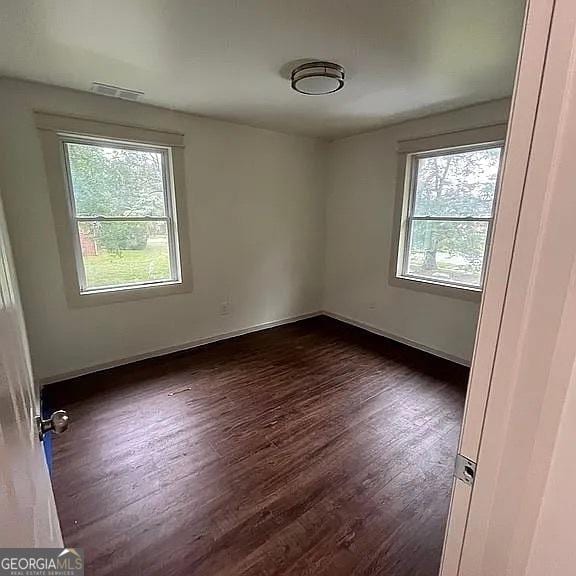 empty room with dark wood-type flooring