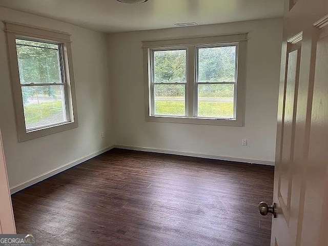 spare room with dark hardwood / wood-style flooring