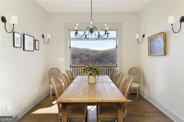 dining space featuring dark wood-type flooring and an inviting chandelier
