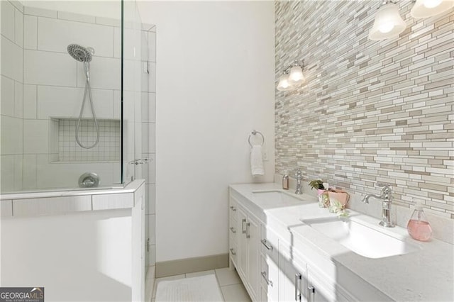 bathroom featuring tile patterned floors, vanity, a tile shower, and decorative backsplash