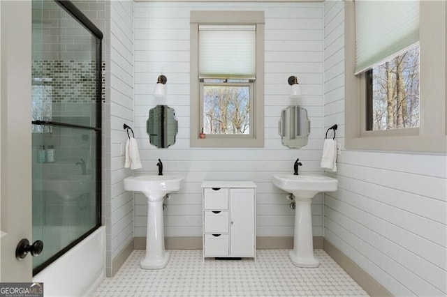 bathroom with tile patterned flooring, plenty of natural light, and combined bath / shower with glass door