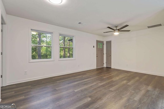 empty room with ceiling fan and dark wood-type flooring