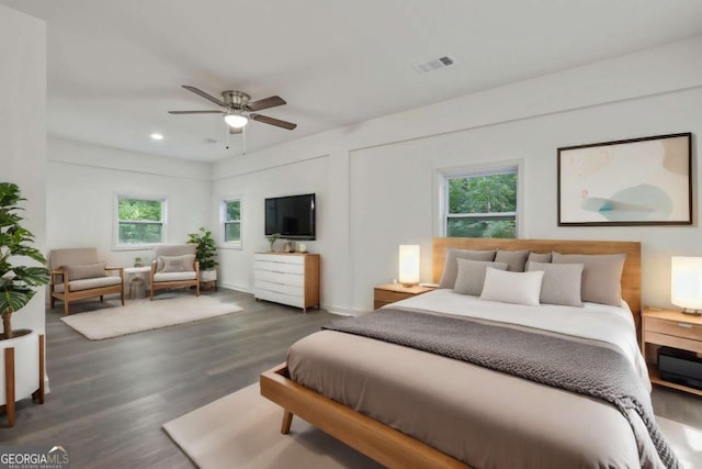 bedroom with multiple windows, ceiling fan, and dark wood-type flooring