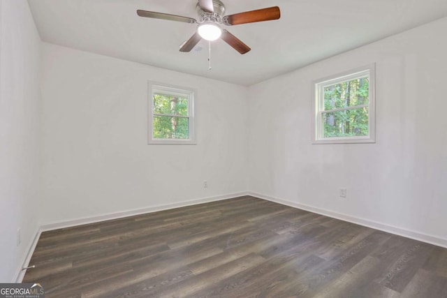 spare room with dark hardwood / wood-style flooring, ceiling fan, and plenty of natural light