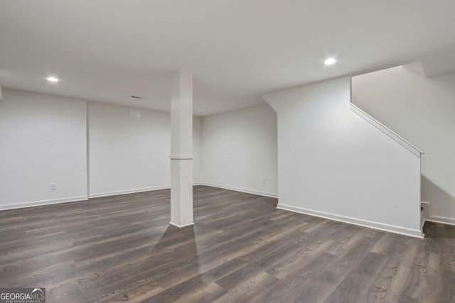 basement with dark hardwood / wood-style flooring